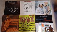 Photo of six assorted vinyl records laid flat showing front covers by various artists including Spectoramp, The Yardbirds, and The Who.