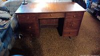 Full front view of the 7 drawer wood desk showing the wood grain finish and round drawer pulls.