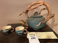 Full view of teapot, two cups, invoice and lot tag on table