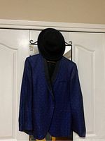 Full view of dark blue dinner jacket with black shawl collar and black top hat on a hanger.