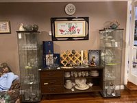 Wide view showing both black-framed glass display cases filled with crystalware