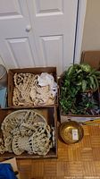 Overview of macrame plant hangers, faux plants, and brass bowl in boxes