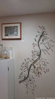 Photo of the metal wall tree branch art and the shadow box art mounted on the wall with jars on a nearby surface, jars not included.