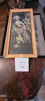 Photo of vintage feather wall hanging in wooden frame showing bird made from feathers.