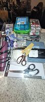 Overview of the crafting supplies including boxes, scissors, and glue on a counter.