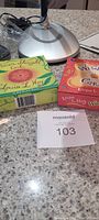 Magnifying lamp base, two boxes of positive affirmation cards by Louise Hay on countertop