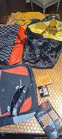 Photo shows Lesportsac duffel bag, travel bag, Sheraton bag, and various wallets arranged on a table.