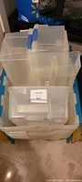 Stack of clear plastic storage containers with blue and yellow latches, showing the top and side views of different sizes.
