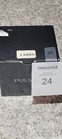 Black rectangular box labeled "LADIES" indicating the watch is for women, box has some wear and a sticker tear.