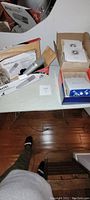 Overview of Apex181 microphone in box, Mini M Box audio interface in box, mic holder, and cables on a table.