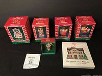Boxed McDonald's Christmas ornaments and an unopened 1997 collectible house kit on display on a black surface.
