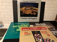 Lot of four McDonald's restaurant advertising signs showing Chicken McNuggets, Shamrock Shake, McRib and Treasure Cups.
