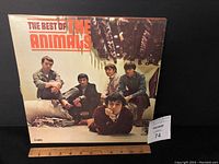 Front cover of the vinyl record album 'The Best of The Animals' showing the band members posing seated in a corridor.