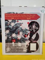 Box of 19ft Christmas string lights with clear white snowflake LEDs, USB powered featuring product details and images of the snowflake light and USB plug.