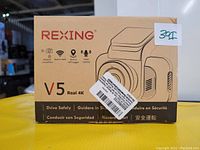 Box of Rexing V5 Real 4K dash camera showing branding, model, and key features such as modular capabilities, built-in WiFi, GPS support, and voice control.
