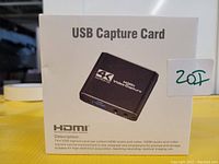 Photo of the front of the retail box showing the USB capture card, labeled 'USB Capture Card' with an image of the device, and 4K Ultra HD HDMI video capture branding.