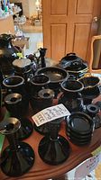 Overview of entire black amethyst glassware lot on wooden table