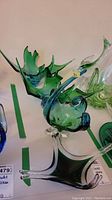 Three green and clear Chalet art glass pieces on tabletop, assorted shapes