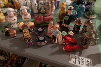 Collection of 19 ceramic salt and pepper shakers on table, including chefs, fruit, birds, fishermen, and beer steins.