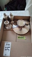 Top view photo showing 2 salt and pepper shakers and 2 candle stick holders in a box