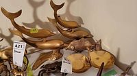 Photo showing brass dolphin figurines and fish figurine with crab and trinket bowls.