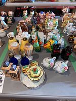 Overview of multiple ceramic salt and pepper shaker sets, various animal and novelty shapes, including cats, pigs, birds, ducks, owls, with some visible chips