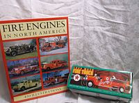 Photo showing the hardcover book titled 'Fire Engines in North America' and the boxed Ertl 1929 Mack Fire Truck Bank.
