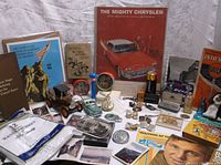 Wide view of vintage collectibles spread out including advertising, books, and coin banks.