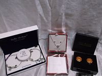 Overview of the three jewelry sets in their respective original boxes: Bella Perlina bracelet set, Napier necklace and earrings set, Joan Rivers earrings in a black box.