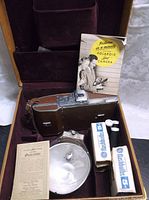 Polaroid Land Camera Model 95 in brown leather case with included accessories and documentation inside.