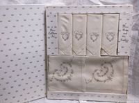 Original packaging showing 4 placemats and 4 napkins arranged inside, showcasing embroidery and presentation