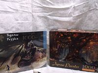 Two puzzle boxes side by side: Green Dragon and Fantasy Forest, each 1000 pieces.