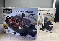 Photo of two Granitestone Diamond Electric Skillet boxes, showing 12 inch size and image of the skillet with glass lid and cooked food.