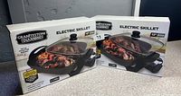 Two boxed Granitestone Diamond Electric Skillet units, 12 inch models, front view showing prices and box condition.