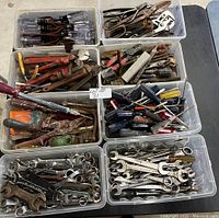 Overview of 8 plastic bins filled with mixed hand tools including wrenches, pliers, and screwdrivers.
