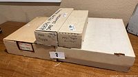 Three long cardboard boxes labeled with card set details including 1989 Topps, 1951 Topps Football, and a larger unmarked box.