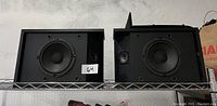 Front view showing both Bose speakers side by side displaying woofer and tweeter drivers.