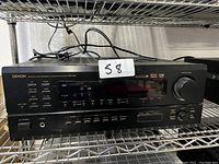 Front view of Denon AVR-1802 stereo receiver showing control panel with volume knob, input buttons, display, and headphone jack.