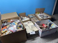 Wide shot showing several boxes filled with mixed and stacked sports cards including loose cards and packs.