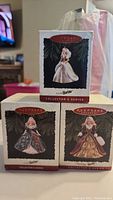 Three Hallmark Keepsake Holiday Barbie ornaments in original boxes with front images visible.