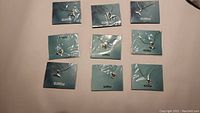 Nine silvertone Effy necklaces individually packaged on blue cards with silver pendants visible