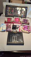 Full view of the lot featuring makeup and body care items including gift sets, makeup palette, brushes, and small products.