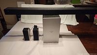 Vizio soundbar, subwoofer, and two surround speakers arranged on a table for clear view.