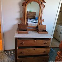 Full view of Eastlake style wooden vanity showing marble top, three front drawers opened, two removable top boxes, and attached mirror with carved wooden frame.