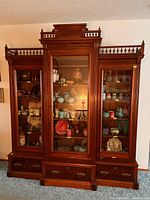 Front view of the three-piece breakfront cabinet showing overall design and condition