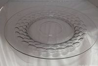 Side angled photo showing the textured bubble pattern around the center of the platter, the clear blue tint of the glass, and smooth rim.