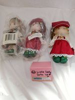 Three vintage Little Holly Dolls, two in original plastic packaging, one out of package, with auction tag.