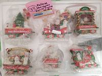 All six Maltese dog Christmas Express train figurines together wrapped in plastic bags for condition and packaging view