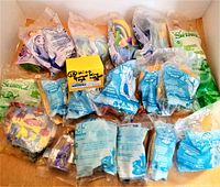 Photo showing all 18 Burger King toys individually packaged in original sealed plastic bags, with visible branding for Shrek 2 and other series.