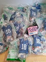 Lot of 24 packaged Burger King NFL Colts #18 collectible toys, all sealed in original plastic packaging, showing front view of toys with blue jerseys and helmets.